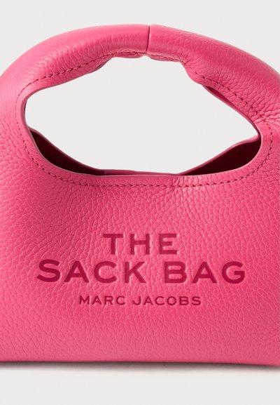 Rozā ādas rokassomiņa ar apaļu rokturi, iegrieztu tekstu "THE SACK BAG" un "MARC JACOBS", ar teksturētu virsmu.
