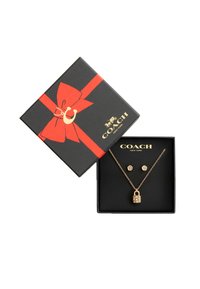 Set di gioielli dorati in una scatola nera con un nastro rosso e un fiocco. Comprende una collana con un pendente a forma di lucchetto e orecchini a perno coordinati.