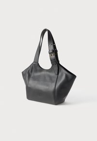Bolsa tote de couro preta com um corpo espaçoso, parte superior curvada, alça ajustável com fivela e detalhe de logotipo em relevo na frente.