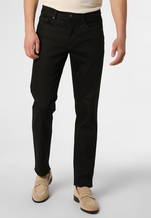Black denim pants with a regular fit, featuring five pockets and visible stitching. Worn with light beige loafers.