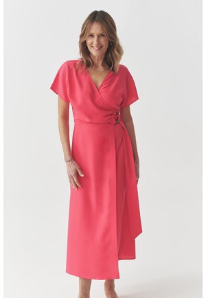 Wrap dress in bright pink fabric, featuring short sleeves, a deep V-neck, and a side tie with a circular accent at the waist.