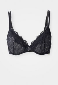 Soutien-gorge en dentelle noire avec un tissu transparent orné de motifs à pois dorés, des bords festonnés, des bretelles réglables et un accent en matériau doré.