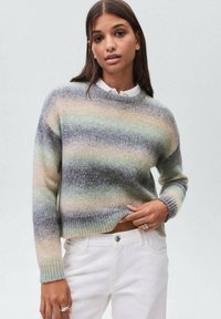 Pleten pulover z okroglim izrezom, ki ima vodoravne črte v sivih, pastelno zelenih in bež odtenkih. Rebrasti patent in rob.