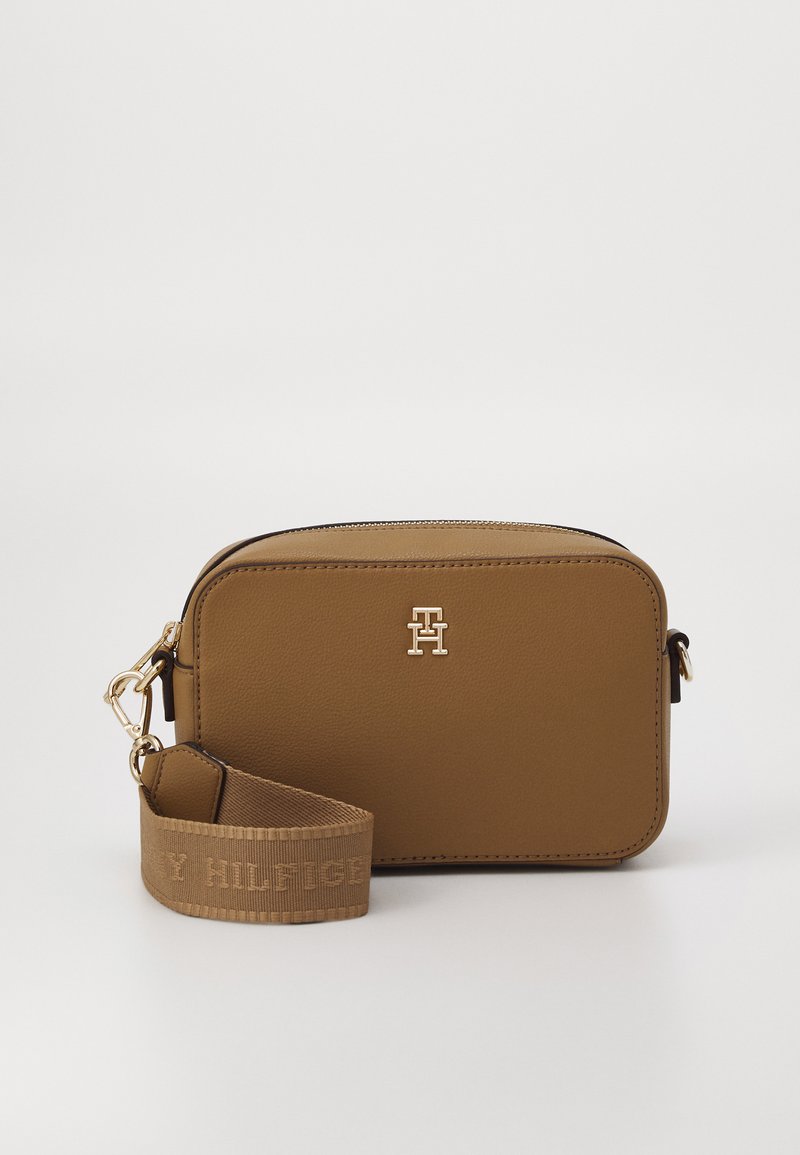 Hnedá syntetická kožená crossbody taška so zlatým logom, obdĺžnikový tvar, zips na uzatvorenie a tkaný popruh s embosovaným brandingom.