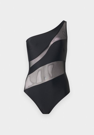 Μαύρο ολόσωμο μαγιό με έναν ώμο και διαγώνιες διαφανείς επενδύσεις από δίχτυ στο σώμα και τη μέση, σε απλό ανοιχτό φόντο.