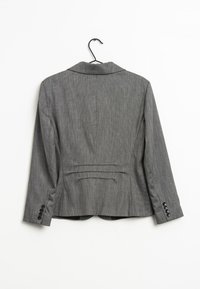 Grå skræddersyet blazer med et tekstureret stof, smal krave og enkelt knapmanchetter. Har bagfoldninger og en tætsiddende silhuet.