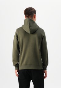 Felpa verde oliva con cappuccio, maniche lunghe e orlo a costine. Tessuto liscio e vestibilità casual, vista da dietro.