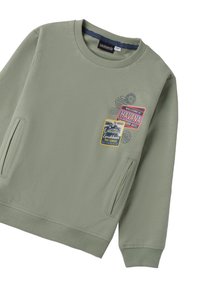 Sudadera de algodón verde con cuello redondo, mangas largas, bolsillos laterales y múltiples parches coloridos con diseños relacionados con los viajes.