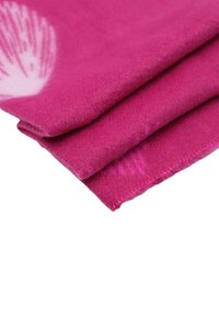 Coperta in pile rosa con una texture morbida, piegata per mostrare la superficie liscia e un sottile motivo floreale in un angolo.
