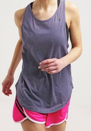 Persoon joggend met een loszittende paarse tanktop en felroze sportshorts met witte rand op een lichte achtergrond.
