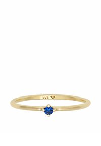 Anello in metallo color oro con una piccola gemma blu al centro, dotato di una fascia liscia e sottile. Marcato "925" all'interno della fascia.