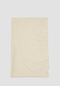 Beige sjaal met een ruitpatroon gemaakt van zilveren pailletjes. De randen hebben een ruwe, franje afwerking. De stof lijkt zacht en lichtgewicht.