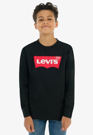 T-shirt noir à manches longues avec un logo rouge Levi's au centre. Fabriqué en coton, il présente un col rond et des poignet ajustés. Porté avec un jean bleu.