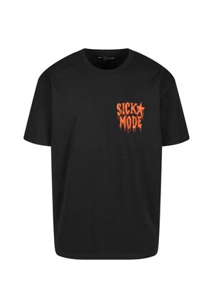 T-shirt en coton noir à manches courtes, avec un graphique orange "SICKO MODE" dans un style dégoulinant sur la partie gauche de la poitrine.