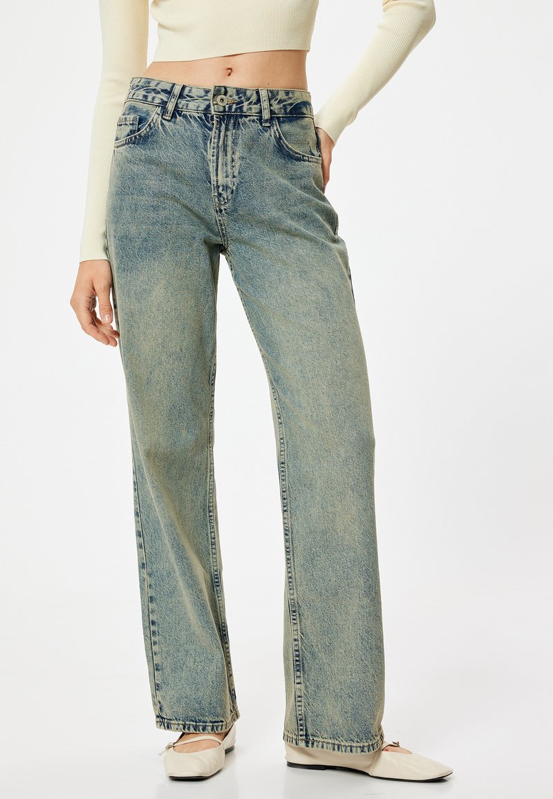 Jeans in denim chiaro con vestibilità rilassata, vita alta e orlo leggermente sfilacciato. Presentano uno stile a cinque tasche e un leggero sbiadito.