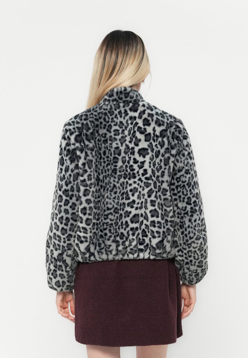 Faux-Fur-Jacke mit einem grauen Leopardenmuster, ausgestattet mit einem Kragen und elastischem Saum. Weicher Stoff und voluminöse Ärmel.