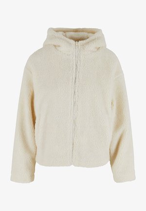 Veste à capuche en polaire de couleur crème avec une fermeture éclair sur le devant, présentant un tissu texturé et pelucheux et une capuche attachée pour plus de chaleur.
