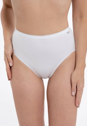 Woman wearing high-waist white cotton briefs, standing with hands relaxed at sides against a plain white background.