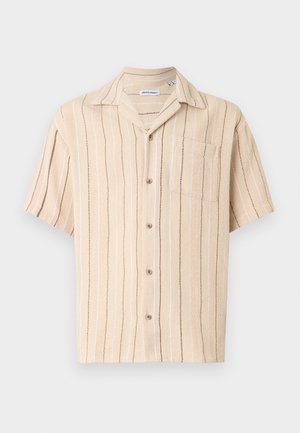 Chemise beige à manches courtes avec boutons, rayures verticales marron et blanches, et une poche poitrine, posée à plat sur un fond blanc.