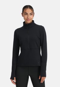 Zwart pullover met lange mouwen van soepel materiaal, voorzien van een ritssluiting bij de kraag, een getailleerde pasvorm en duimgaten in de mouwen.