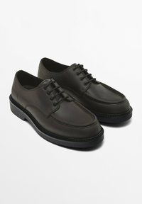 Brown leather shoes with a smooth finish, round toe, and lace-up design. Features black rubber sole and tonal stitching accents.