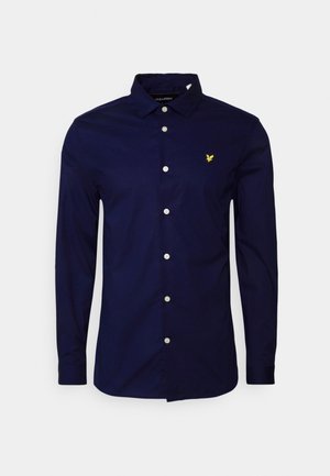 Navy blue long-sleeve button-up shirt with collar and small yellow eagle logo on the left chest.