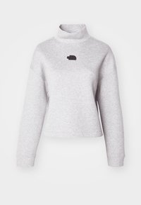 Světlé šedé rolákové mikina s volným střihem, má dlouhé rukávy a malé černé logo na hrudi. Měkká textura látky.