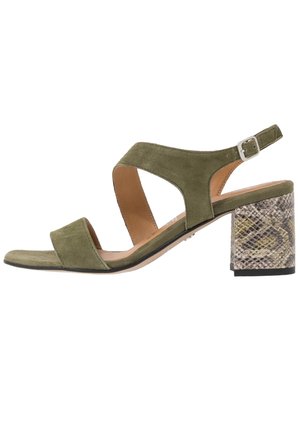 Zielone zamszowe sandały z dwoma szerokimi paskami i paskiem wokół kostki z srebrnym zapięciem. Słupkowy obcas ma wzór węża w ziemistych kolorach.