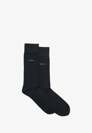 Calzini neri con una texture liscia e un bordo a coste. Presentano un discreto logo "BOSS" grigio sul lato. Design standard con lunghezza alla caviglia.