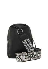 Sac à dos en cuir noir avec une forme incurvée, comportant un détail en forme d'anneau argenté et une sangle réglable à motifs en noir et blanc avec des designs géométriques.
