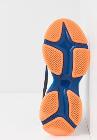 Suola di scarpa con corpo in plastica blu e suola in gomma arancione. Presenta un motivo a zigzag per trazione e stabilità, con una finitura testurizzata.