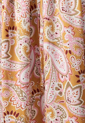 Un tissu multicolore présente un motif paisley en rose, blanc et marron sur un fond moutarde ; texture douce avec un design fluide.