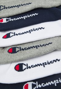 Strumpor i grått, marinblått och vitt, med "Champion"-logotypen i kontrasterande färger. Mjukt tyg med en slät struktur.