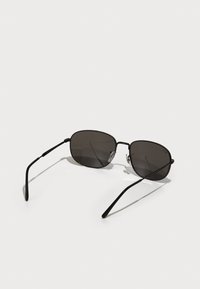 Ochelari de soare negri cu lentile rectangulare, rame metalice și brațe subțiri din sârmă. Au tampoane nazale transparente pentru confort.