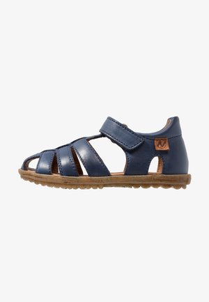 Sandalia de cuero azul marino con diseño abierto, que cuenta con múltiples correas, cierre ajustable de Velcro y suela de goma texturizada para mayor agarre.