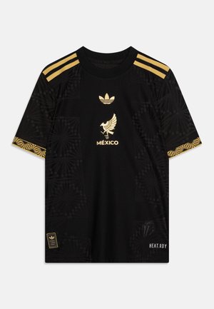 Čierny dres s krátkym rukávom s zlatými akcentmi, emblémom orla, logom Adidas, okrúhlym výstrihom a vzorovanou textúrou po stranách.
