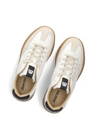 Witte en beige sneakers met een glad leren bovenwerk, een tan rubberen zool en zwarte hielaccenten; heeft veters en een gevoerde binnenzool.