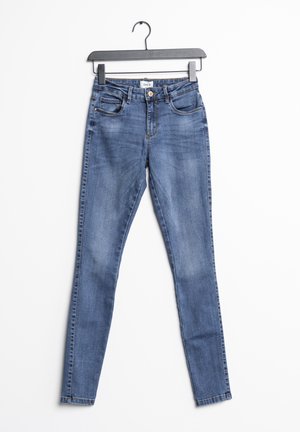 Jean en denim bleu skinny avec taille mi-haute, cinq poches et une finition légèrement délavée ; il présente un bouton en métal et des coutures contrastées.