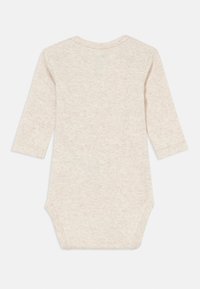 Bodysuit de manga larga color beige claro, fabricado con tela suave y texturizada. Cuenta con un escote redondo y broches en la parte inferior para facilitar el vestir.