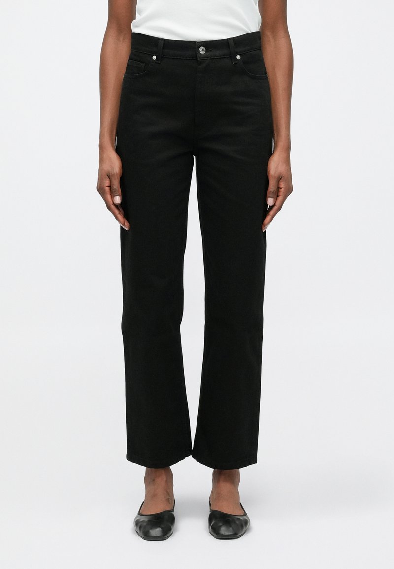 Čierne široké džínsy vyrobené z odolnej bavlny s hladkou textúrou, so prednými vreckami a striebornými kovovými doplnkami.