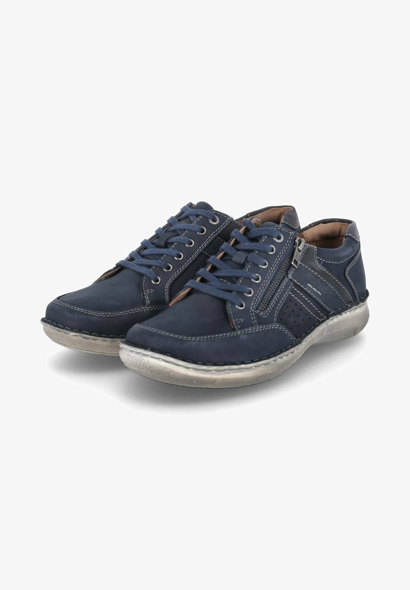 Navy blue leather sneakers with laces, a side zipper, perforated detailing, and contrasting gray stitching on a textured rubber sole.