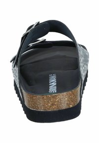 Black and white patterned slide sandal with a cork sole, textured footbed, and adjustable strap featuring a metal buckle accent.