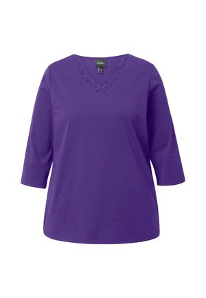 Fioletowa bluzka damska w serek z rękawami 3/4 i falbaniastym koronkowym wykończeniem przy dekolcie, prezentowana na białym tle.