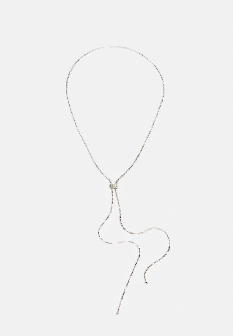 Collar de plata con una cadena flexible y delgada, con un lazo y dos hebras colgantes, que exhibe una textura suave y un diseño minimalista.