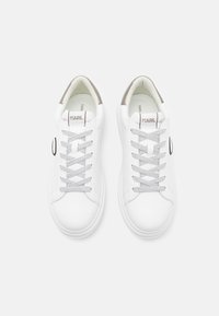 Vita lädersneakers med grå detaljer, rund tå, kontrasterande snören och logotypdetalj på sidan. Slät textur, minimalistisk design.