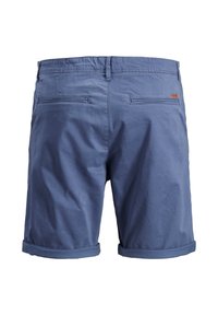 Modré bavlněné šortky s ohrnutými lemy, dvěma zadními kapsami a detailem štítku na pravé straně. Hladká textura a neformální design.