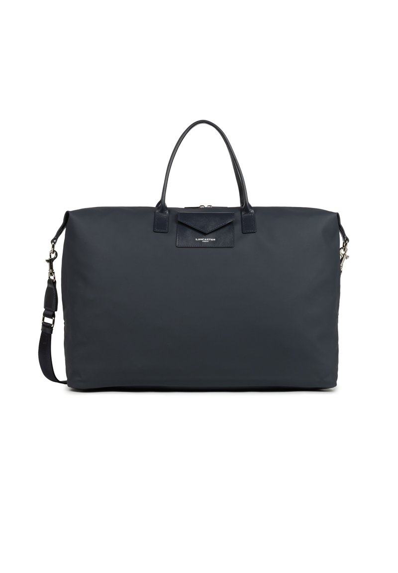 Borsa duffle in nylon navy con due manici superiori, strap regolabile e dettagli in pelle. Presenta una tasca frontale con chiusura a patta.