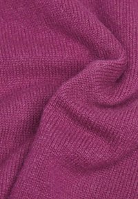 Lila gestrickter Stoff, der eine weiche Textur mit einem glatten, gleichmäßigen Gewebe aufweist. Die Farbe ist lebhaft und tief mit subtiler Schattierung.