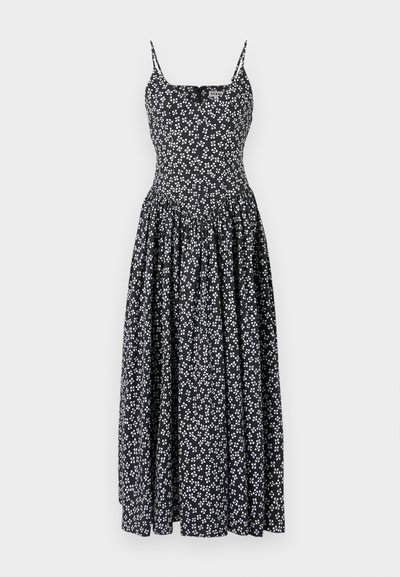 Vestido maxi preto com padrões florais brancos, apresentando alças finas, um corpete justo e uma saia godê fluida. Feito de um tecido leve.