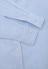 Hellblau-weiß gestreifte Bluse mit geknöpften Manschetten und Kragen. Verfügt über kleine Knöpfe und eine glatte Textur.